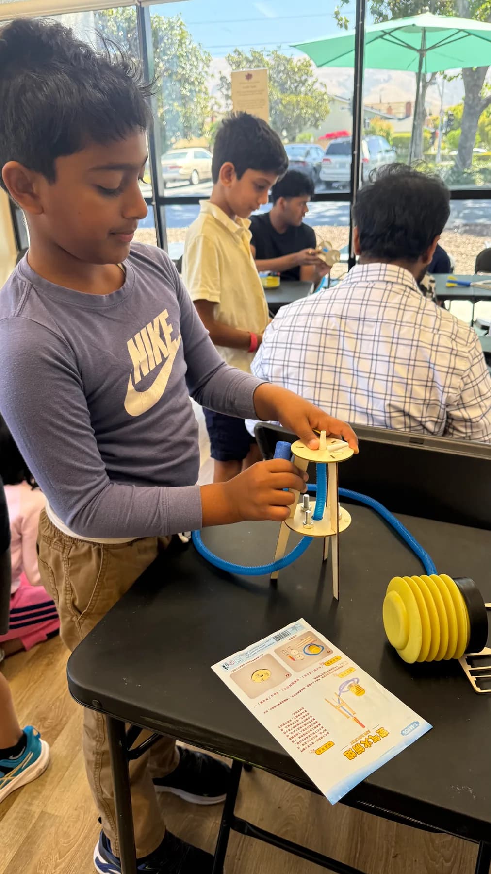 A child testing an air-pressure model during a hands-on engineering activity