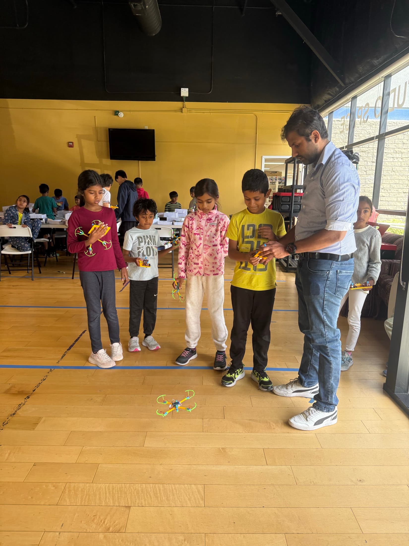 Children lined up and ready for an indoor teamwork challenge